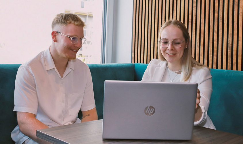 Zwei Personen vor einem Lap Top